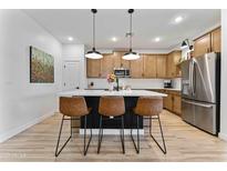 Modern kitchen boasts pendant lighting, stainless steel appliances, and a stylish island with bar seating at 27510 N 30Th Ln, Phoenix, AZ 85083