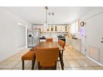 Bright kitchen featuring white cabinets, stainless steel appliances, and dining area with seating at 3701 E Karen Dr, Phoenix, AZ 85032