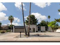 Stunning single-story home featuring desert landscaping, palm trees, and modern architectural details at 5341 E Sheena Dr, Scottsdale, AZ 85254
