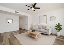 Bright living room features modern ceiling fan, neutral paint and decor, plus wood-look flooring at 7801 N 44Th Dr # 1003, Glendale, AZ 85301