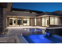 Backyard with a modern rectangular pool featuring a waterfall and tiled patio at 9750 E Troon North Dr, Scottsdale, AZ 85262