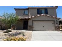 Charming two-story home featuring a two-car garage and desert landscaping at 1074 W West Virginia Ave, Florence, AZ 85132