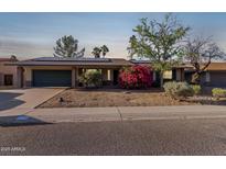 Charming single-story home boasts solar panels, a lush bougainvillea, and a two-car garage at 116 E Helena Dr, Phoenix, AZ 85022