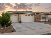Inviting home featuring a three-car garage, desert landscaping, and a neutral color palette at 12176 E Chevelon Trl, Gold Canyon, AZ 85118