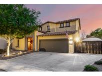 Charming two-story home with a two-car garage, mature tree, and an inviting entrance, creating an appealing curb presence at 17363 W Lisbon Ln, Surprise, AZ 85388