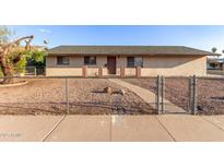 Charming single-story home with a neutral-toned exterior, gravel landscaping, and a fenced front yard at 1751 W Carol Ave, Mesa, AZ 85202
