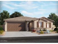 Charming single-story home with a two-car garage and stone accents, complemented by a well-manicured lawn and desert landscaping at 17721 W Ford St, Goodyear, AZ 85338