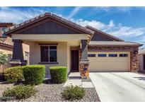 Charming single-story home with a two-car garage, stone accents, and well-maintained landscaping in front at 18808 W Solano Dr, Litchfield Park, AZ 85340