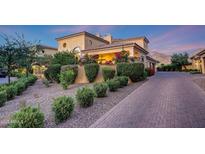 Inviting Mediterranean-style home boasts lush landscaping and charming brick driveway at 18927 N 101St St, Scottsdale, AZ 85255