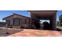 Inviting single-story home featuring a large covered patio and a spacious driveway for parking at 316 S 74Th Way, Mesa, AZ 85208