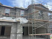 Two-story stucco home exterior under construction showcases a modern design with scaffolding, offering a glimpse of potential at 5840 E Covey Ln, Phoenix, AZ 85054