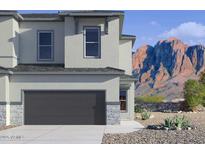 Modern two-story home with a gray garage door, stone accents, and mountain views at 5844 E Covey Ln, Phoenix, AZ 85054
