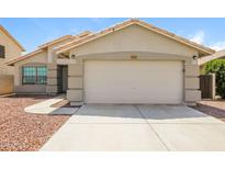 Charming single-story home with a well-maintained front yard, featuring a two car garage and desert landscaping at 6875 W Townley Ave, Peoria, AZ 85345