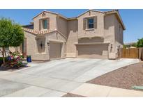 Beautiful two-story home featuring a three-car garage and a well-maintained desert landscape at 15562 W Cameron Dr, Surprise, AZ 85379