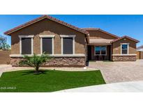 Inviting single-story home featuring a landscaped front yard with desert accents and a brick paved driveway at 15740 W Washington St, Goodyear, AZ 85338