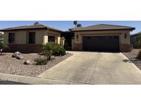 Charming single-story home featuring a desert landscape, tile roof, and attached garage at 15843 W Edgemont Ave, Goodyear, AZ 85395