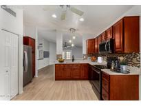 Well-lit kitchen with stainless steel appliances, wooden cabinetry, and stone countertops at 19833 N 47Th Ln, Glendale, AZ 85308
