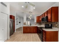 Well-lit kitchen features wood cabinets, stainless steel appliances, and mosaic tile backsplash at 19833 N 47Th Ln, Glendale, AZ 85308