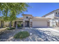Beautiful single-story home with a two-car garage and front yard featuring gravel landscaping and desert foliage at 22333 E Calle De Flores St, Queen Creek, AZ 85142