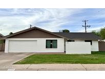 Charming single-story home with a white exterior, attached garage, and well-maintained lawn at 228 E Del Rio Dr, Tempe, AZ 85282