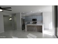 Bright kitchen boasts stainless steel appliances, stylish island, and updated cabinets, perfect for modern living at 29462 N 126Th Ln, Peoria, AZ 85383