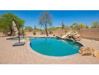 Backyard pool with desert landscaping, brick patio, and slide feature for recreational enjoyment at 32525 N 41St Way, Cave Creek, AZ 85331