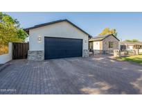 Wide brick driveway leading to a modern home with a spacious two-car garage at 3834 E Clarendon Ave, Phoenix, AZ 85018