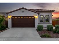 Inviting front exterior featuring a tile roof, arched windows, two-car garage, and beautifully landscaped yard at 4352 N 91St Gln, Phoenix, AZ 85037