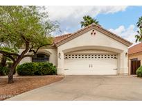 Charming single Gathering home with a wide driveway leading to a large garage and manicured front yard at 4738 N Greenview W Cir, Litchfield Park, AZ 85340