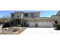 Two-story home featuring a three-car garage, stone accents, and well-maintained landscaping at 6619 W Cordia Ln, Phoenix, AZ 85083