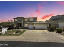 Stunning two-story home featuring a 3-car garage, desert landscaping, and a picturesque sunset backdrop at 6619 W Cordia Ln, Phoenix, AZ 85083