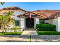 Charming home featuring lush landscaping, an American flag and a beautifully tiled roof at 6941 W Voltaire Ave, Peoria, AZ 85381