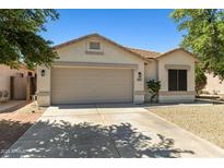 Charming single-story home with neutral stucco, a two-car garage, and desert landscaping at 9343 W Harmony Ln, Peoria, AZ 85382