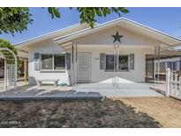 Charming single story home featuring a covered front porch with decorative railings and a star accent at 120 S Olive --, Mesa, AZ 85204