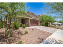 Charming single-story home featuring a stone-accented facade, two-car garage, and desert landscaping at 17864 W Fetlock Trl, Surprise, AZ 85387