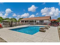 Backyard pool with tiled coping, outdoor seating and an exterior view of the home at 18132 E Vencino St, Gilbert, AZ 85298