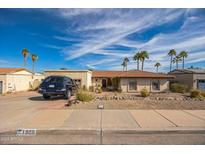 Charming single-story home featuring desert landscaping, red tile roof, and a private driveway on a sunny day at 1908 E Beck Ln, Phoenix, AZ 85022