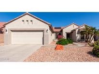 Charming single-story home featuring desert landscaping, a two-car garage, and a red tile roof at 20223 N Sundance Way, Surprise, AZ 85374