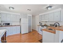 Functional kitchen with white appliances, wood countertops, and a gas range stove at 2121 N Center St # 198, Mesa, AZ 85201