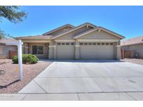 Charming single-story home with a well-manicured lawn and a three-car garage at 22121 N Greenland Park Dr, Maricopa, AZ 85139