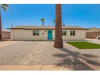 Charming single-story home with a well-maintained yard, stone landscaping, and a bright blue front door at 3302 N 40Th Dr, Phoenix, AZ 85019