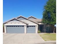 Charming single-story home with a three-car garage, neutral color palette, and well-manicured landscaping at 34970 N Spur Cir, San Tan Valley, AZ 85144