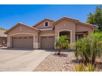 Charming single-story home featuring a three-car garage, desert landscaping, and neutral stucco facade at 3823 E Kroll Dr, Gilbert, AZ 85234