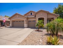 Charming single-story home featuring a three-car garage, desert landscaping, and neutral stucco facade at 3823 E Kroll Dr, Gilbert, AZ 85234