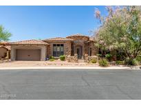 Charming stone home featuring a tile roof, two-car garage, and beautiful landscaping at 7134 E Sandia St, Mesa, AZ 85207