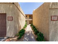 Inviting walkway with green landscaping leads to condo units in a well-maintained complex at 8301 N 21St Dr # F102, Phoenix, AZ 85021