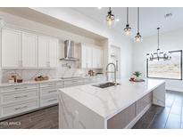 Bright kitchen featuring a waterfall island, stainless steel appliances, and modern lighting fixtures at 9626 E Bunny Ear E Ln, Gold Canyon, AZ 85118