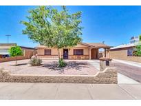 Charming single-story home featuring a well-maintained front yard, xeriscaping, and cozy patio seating at 1018 S Toltec --, Mesa, AZ 85204