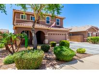 Charming two-story home features a well-manicured front yard with lush greenery and a welcoming facade under a clear blue sky at 13123 W Cottontail Ln, Peoria, AZ 85383