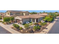 Charming single-story home with lush landscaping and a cozy outdoor patio at 1462 E Sweet Citrus Dr, Queen Creek, AZ 85140